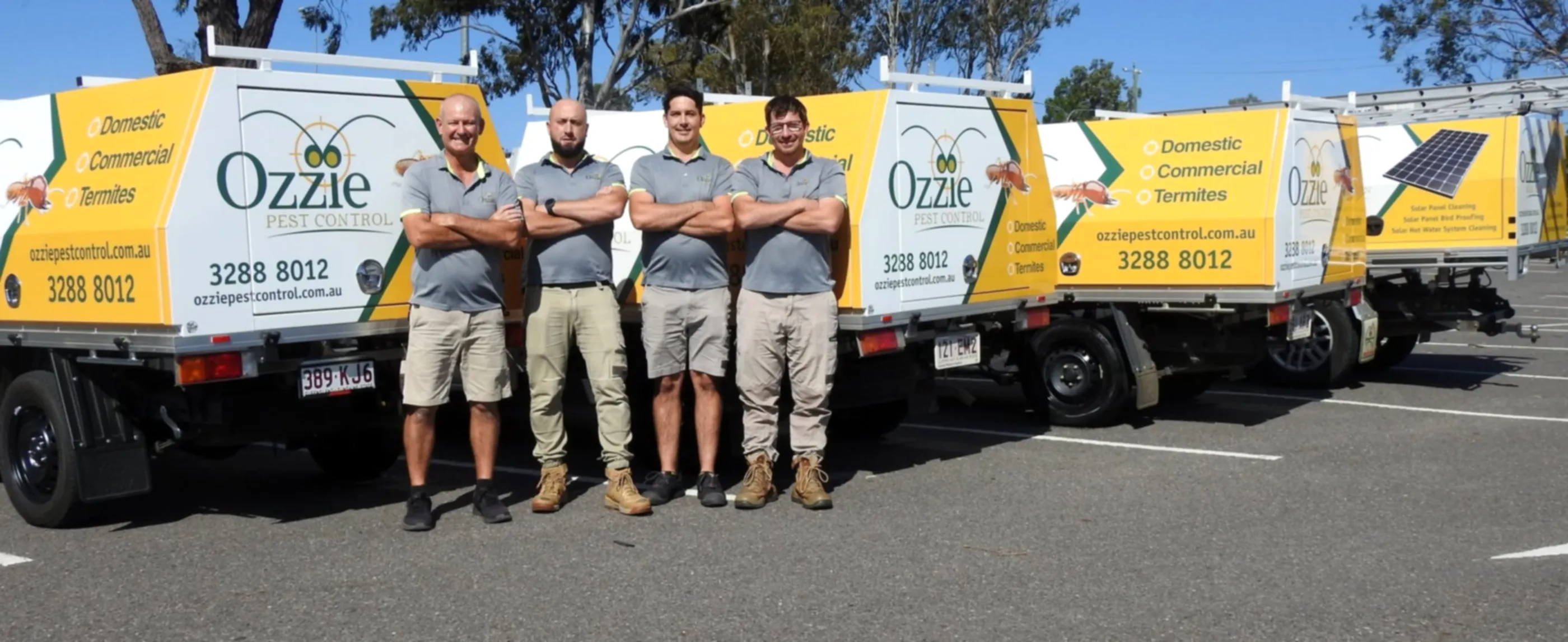 The four Ozzie Pest Control technicians standing in front of their signwritten fleet